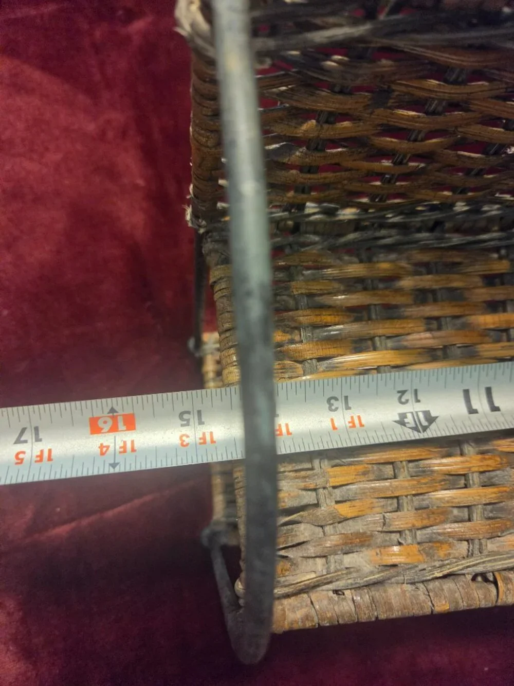 two tier wicker shelf with metal frame adorned with scrollwork some wear